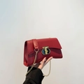 Chic red chain shoulder bag for women featuring a stylish gold and black T-shaped metal clasp - Red