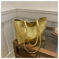 Makro-Detail der glänzend goldenen Krokodil-Lederstruktur an einer großen Tote-Bag - Gold