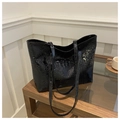 Makro-Detail des schwarzen Kunstleders mit Krokoprägung auf einer großen Shopper-Tasche - Schwarz