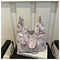 Detail of white tote bag featuring pink butterfly prints and gold metal ring hardware - Pink