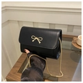 Detail of black crossbody bag with gold bow buckle and elegant metal chain strap - Black