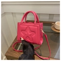 Elegante borsa a mano fucsia quadrata con stella a rilievo in un ambiente da caffè - Rosa Rosso