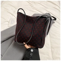 Detailaufnahme einer schwarzen Beuteltasche mit roten Herzen und einer Seidenschleife - Rotes Herz
