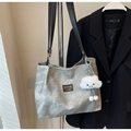 Detalle del bolso tote gris con textura lavada, correas negras y un colgante de nube suave - Gris Claro Con Colgante