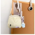 Detalle del bolso beige de nailon con parche Lucky You y colgante de pompón suave - Con Colgante / Amarillo claro