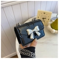 Mini sac à rabat noir brillant avec nœud en métal argenté et bandoulière chaîne - Noir