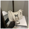 Detalle del adorno de mariposa y textura de mármol en el bolso de hombro beige - Blanco