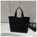 Detail of minimalist black tote bag with vertical pleated texture and dual handles - Black