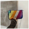 Detailed shot of iridescent rainbow stripes on crossbody bag with metal chain edging - Colorful
