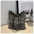 Detalle de bolso tote con estampado de leopardo y correas de cuero sobre mesa de madera - Marrón Oscuro