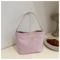Detail of pink canvas tote bag with yellow embroidery on an elegant cafe table - Pink