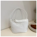 Detail showing white bucket bag with 'pretty and libety' embroidery in a cafe setting - White