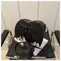 Close-up of black heart-shaped crossbody bag featuring gothic bat wings and corset lacing - Black