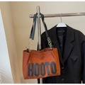 Detail of brown suede tote bag with HOOTO letter print and gold chain strap attachment - Brown