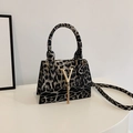 French leopard print handbag with golden V-clasp, metal fringe and top handle - Black