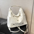 Chic cream pleated tote bag with silver metal butterfly accents and adjustable straps - White