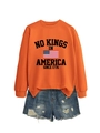 Flat lay of an orange crewneck sweatshirt with No Kings print and ripped denim shorts - Orange (Black Graphic)