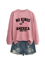 Detail of pink sweatshirt with No Kings in America print and ripped denim shorts - Rose Gold (Black Graphics)