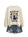 Close-up of beige sweatshirt with 'Just a Girl Who Loves Cats' print and denim shorts - Sand (Black Font)
