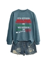 Dettaglio della felpa grigio-azzurra con stampa a tema natalizio e pantaloncini in denim usurati - Felpa blu (motivo testo bianco)
