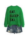 Flat lay of green 'EAT SLEEP SKI' sweatshirt paired with distressed blue denim shorts - S / Grass Green (Black Font)