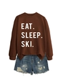 Flat lay of brown Eat Sleep Ski sweatshirt paired with distressed blue denim shorts - Coffee (White Font)