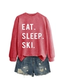 Flat lay of red Eat Sleep Ski sweatshirt and blue ripped denim shorts outfit - Red (White Font)