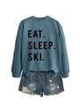 Close-up of Eat Sleep Ski printed sweatshirt paired with distressed denim shorts - Blue (Black Font)