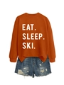 Flat lay detail of orange sweatshirt with Eat Sleep Ski print and distressed denim shorts - Burnt Orange (White Font)