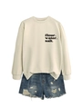 Detail des Mehl-Wasser-Salz-Textdrucks auf einem cremefarbenen Sweatshirt mit Denim-Shorts - Sand (Schwarze Schrift)
