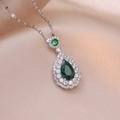 Elegant emerald pear-shaped pendant necklace with cubic zirconia halo on silk background - Emerald Teardrop Pendant (X2852) / Steel