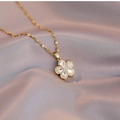 Elegant gold flower pendant necklace with clear zircons on a soft pink silk fabric background - Flower Zirconia Necklace (X1691)