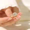 Detail of gold-plated open ring with sparkling sunflower zircon petals on female finger - Gold Rotating Sunflower Style (J0041) / Gold