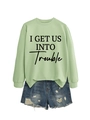 Flachbild von hellgrünem Slogan-Sweatshirt mit Distressed-Denim-Shorts für Streetwear-Look - Olivgrünes Sweatshirt (Schwarze Schrift)