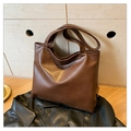 Dettaglio della borsa tote marrone scuro con texture in ecopelle vintage su pelle nera - Marrone