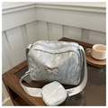 Detailed close-up of a silver textured crossbody bag with a liquid metal butterfly buckle - Silver
