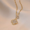 Elegante collana con ciondolo a quadrifoglio dorato e zirconi lucenti su sfondo di seta - Stile Fiore a Quattro Foglie Oro