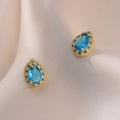 Elegante gouden oorbellen met blauwe druppelstenen en kristallen halo op zijden stof - Blauwe Edelsteen Oorbellen (E0353)