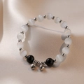 Armband mit Obsidian, Katzenaugenstein und Silberglöckchen auf beige Seide - Schwarz Katzenauge Stein Glocke Armband