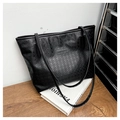 Detalle del bolso tote negro con relieve de estrellas y placa metálica con logo - Negro