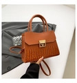 Detail of the brown crocodile texture and gold square buckle on a stylish handbag - Brown
