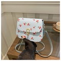 Lichtblauwe crossbodytas met rode kersenprint en een goudkleurige gespsluiting - Blauw
