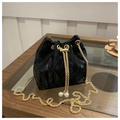 Detail of black velvet bucket bag featuring gold chain and white pearl drawstring toggle - Black