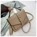 Detail view of khaki square crossbody bag with metal buckle on denim jacket background - Khaki