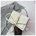 Close-up of white PU leather crossbody bag with golden buckle on blue denim background - Off White