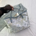 Blue butterfly jacquard tote bag with leather handles on denim and white fabric background - Blue and White