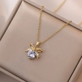 Elegante collana con ciondolo a fiocco dorato e zircone in portagioie beige - Collana Con Ciondolo a Fiocco in Zircone (X2001) / Oro