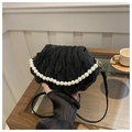 Detail of a black shell-shaped bag featuring a faux pearl handle and elegant pleats - Black