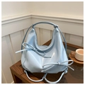 Detail of light blue pleated hobo bag featuring glossy finish and double bow accents - Blue