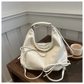Detail of a creamy white moon-shaped hobo bag featuring bow knot ribbons and smooth texture - White